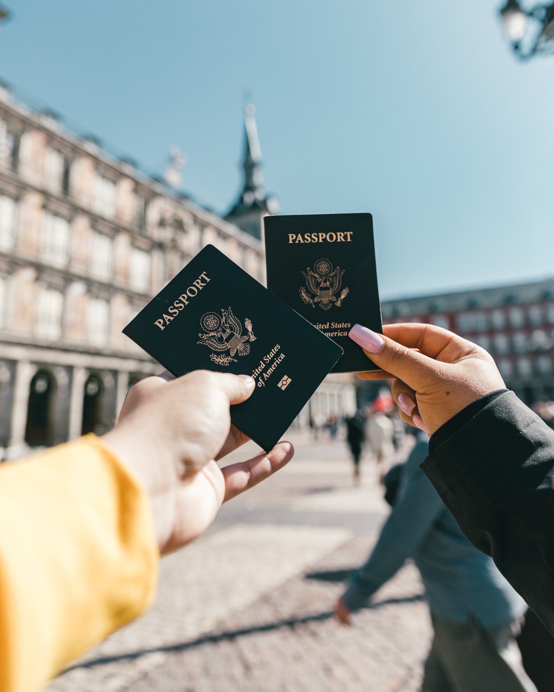 Image of two hands holding US Passports on a sunny day